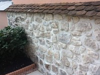 Reconstruction D un muret tombe par la pluie renouveller avec les meme pierre. ciment et joint blanc et  tuilles du sud  craetion de rocaille apercu et lumiere IA  installer